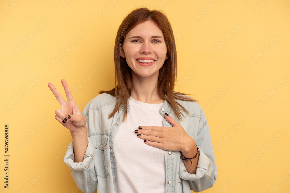 Young English woman isolated on yellow background taking an oath, putting hand on chest. Young English woman isolated on yellow background taking an oath, putting hand on chest.