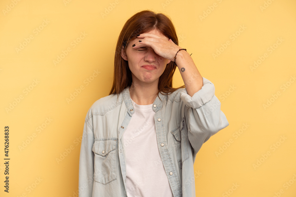 Young English woman isolated on yellow background touching temples and having headache. Young English woman isolated on yellow background touching temples and having headache.