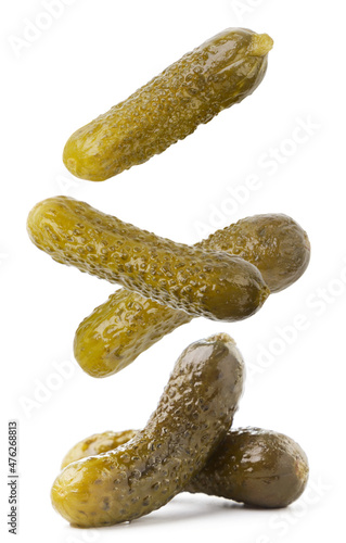 Pickled cucumbers fall on a white background. Isolated