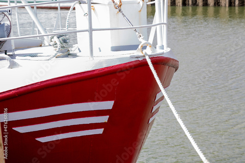 Roter Schiffsbug mit einer Festmacherleine im Hafen photo