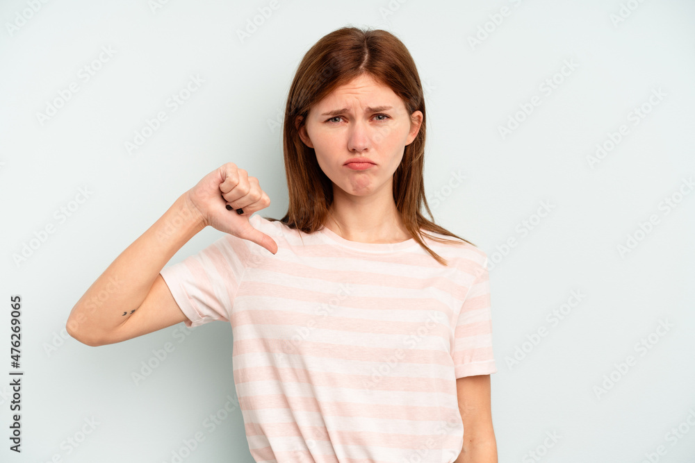 Young English woman isolated on blue background showing thumb down, disappointment concept. Young English woman isolated on blue background showing thumb down, disappointment concept.