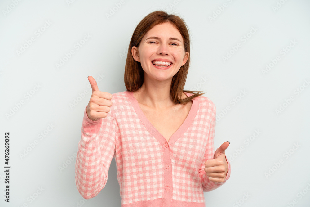 Young English woman isolated on blue background raising both thumbs up, smiling and confident. Young English woman isolated on blue background raising both thumbs up, smiling and confident.