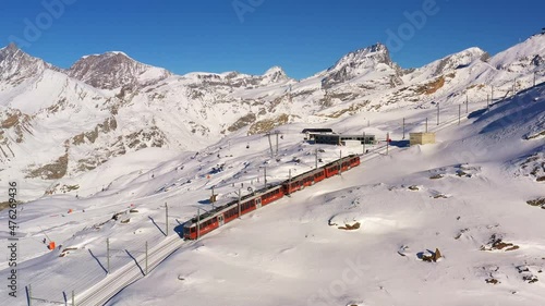 Aerial drone footage of the iconic cogwheel Gornergrat railway in the Zermatt ski resort in the Alps in Valais, Switzerland on a sunny winter day photo