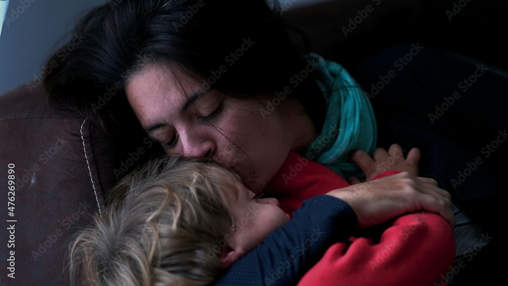 Mother filling child with kisses. casual authentic real life family love and affection Mother filling child with kisses. casual authentic real life family love and affection