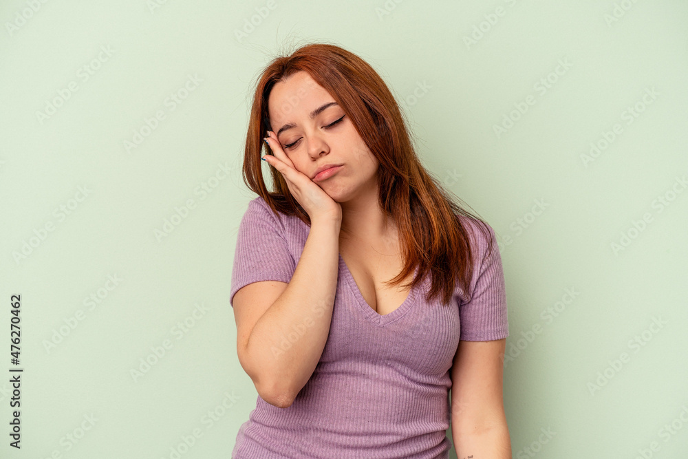 Young caucasian woman isolated on green background who is bored, fatigued and need a relax day. Young caucasian woman isolated on green background who is bored, fatigued and need a relax day.