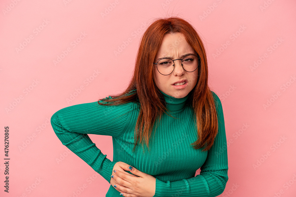 Young caucasian woman isolated on pink background having a liver pain, stomach ache. Young caucasian woman isolated on pink background having a liver pain, stomach ache.