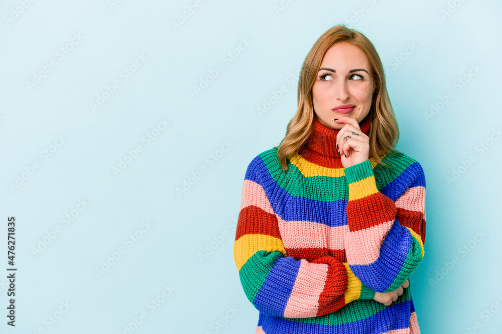 Young caucasian woman isolated on blue background looking sideways with doubtful and skeptical expression. Young caucasian woman isolated on blue background looking sideways with doubtful and skeptical expression.