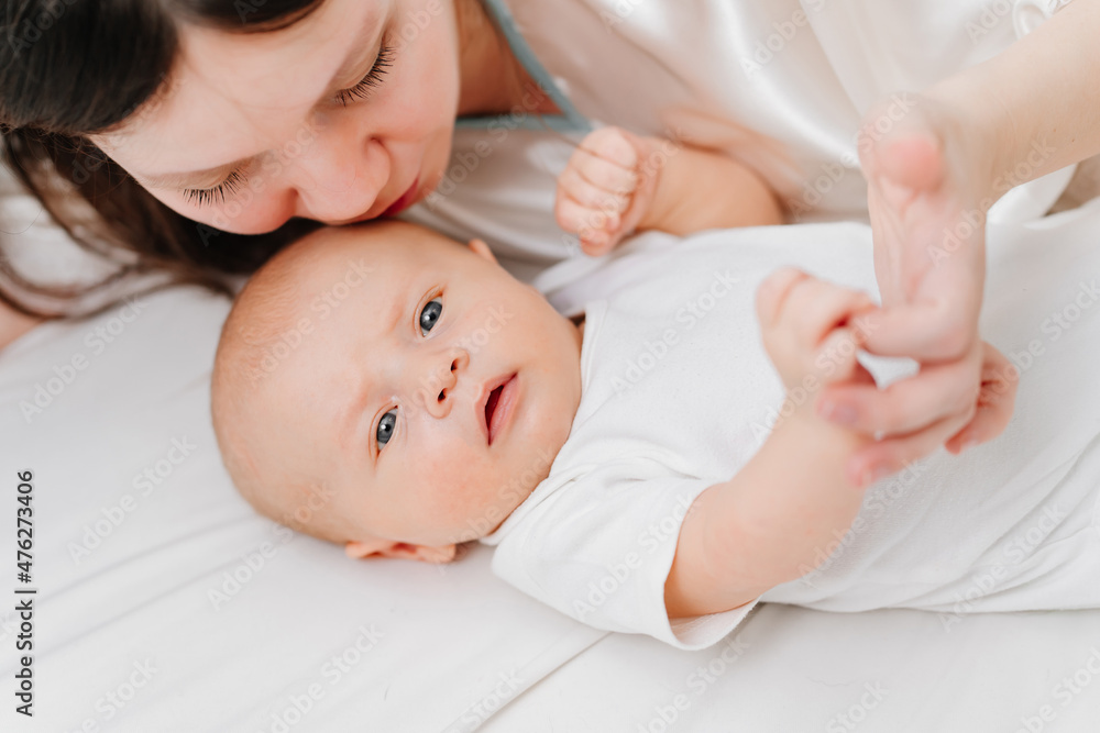 mom lies with the baby in bed. the happiness of motherhood. mom lies with the baby in bed. the happiness of motherhood.