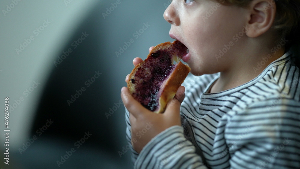 Child eating morning bread with jelly for breakfast Child eating morning bread with jelly for breakfast