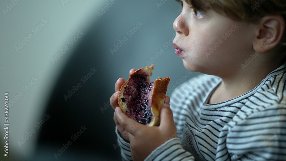 Child eating morning bread with jelly for breakfast Child eating morning bread with jelly for breakfast