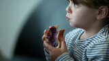 Child eating morning bread with jelly for breakfast