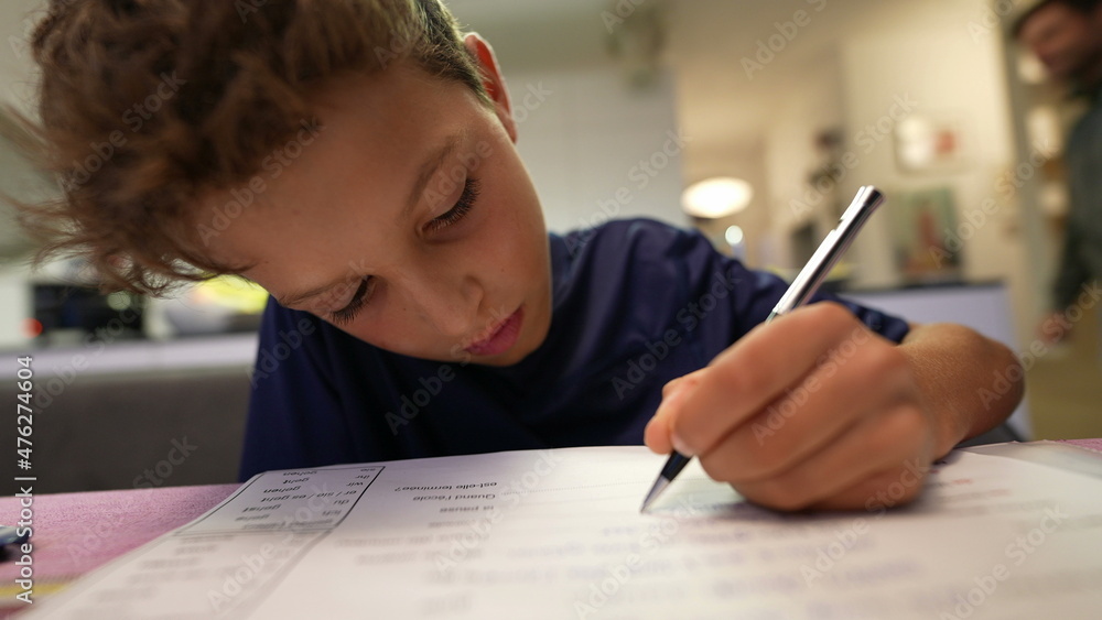 Boy doing homework focused in exam preparation Boy doing homework focused in exam preparation