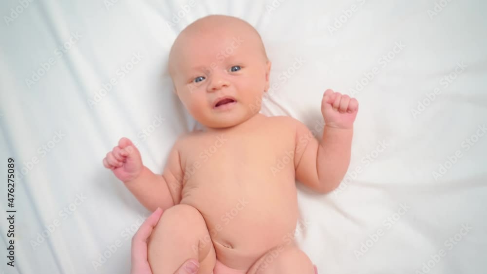 hands do exercises to baby on white sheet. exercise bike for a healthy tummy. hands do exercises to baby on white sheet. exercise bike for a healthy tummy.
