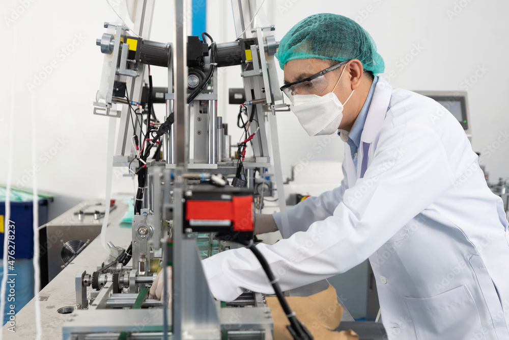 factory worker using machine control panel and producing medical face masks in factory factory worker using machine control panel and producing medical face masks in factory