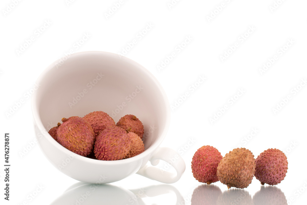 Several ripe sweet Litchi fruits with a white ceramic cup, close-up, isolated on white. Several ripe sweet Litchi fruits with a white ceramic cup, close-up, isolated on white.