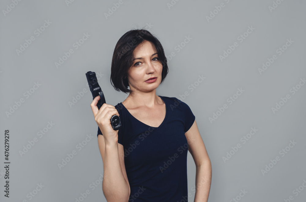 Pistol in the hands of beautiful woman. Pensive look. Pistol in the hands of beautiful woman. Pensive look.