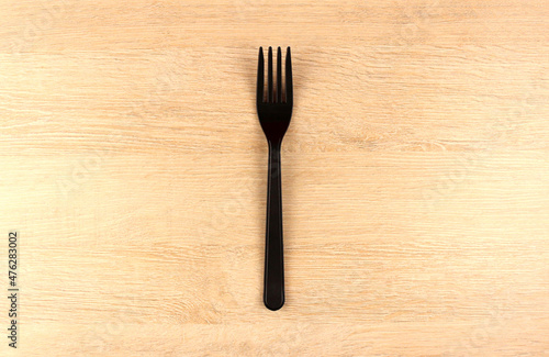 One plastic fork on wooden background