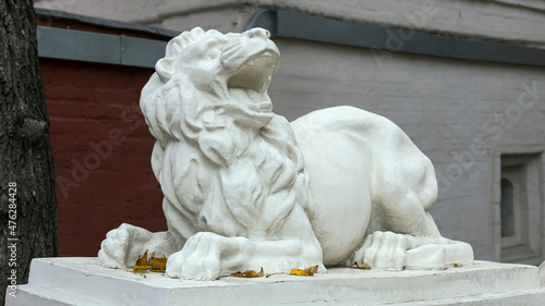 Billede på lærred concrete sculpture of a formidable lion on a pedestal