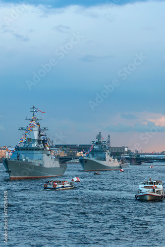 Modern warships. Tourists from pleasure ships and the embankment look at the warships on the Neva. Before the naval parade in St. Petersburg, Russia