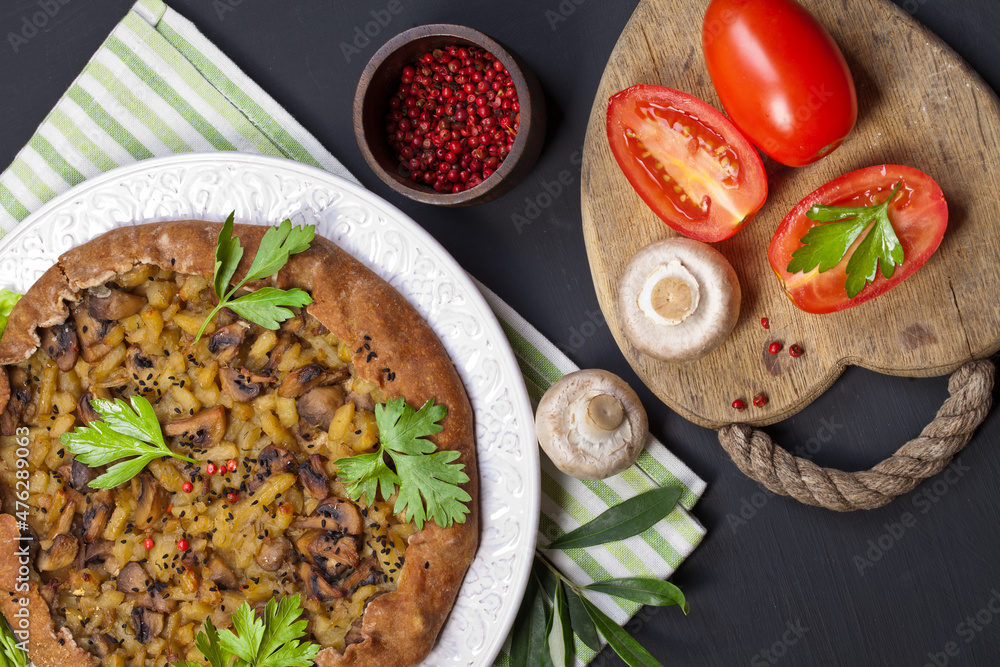 Pie with stewed potatoes and mushrooms on black background Pie with stewed potatoes and mushrooms on black background