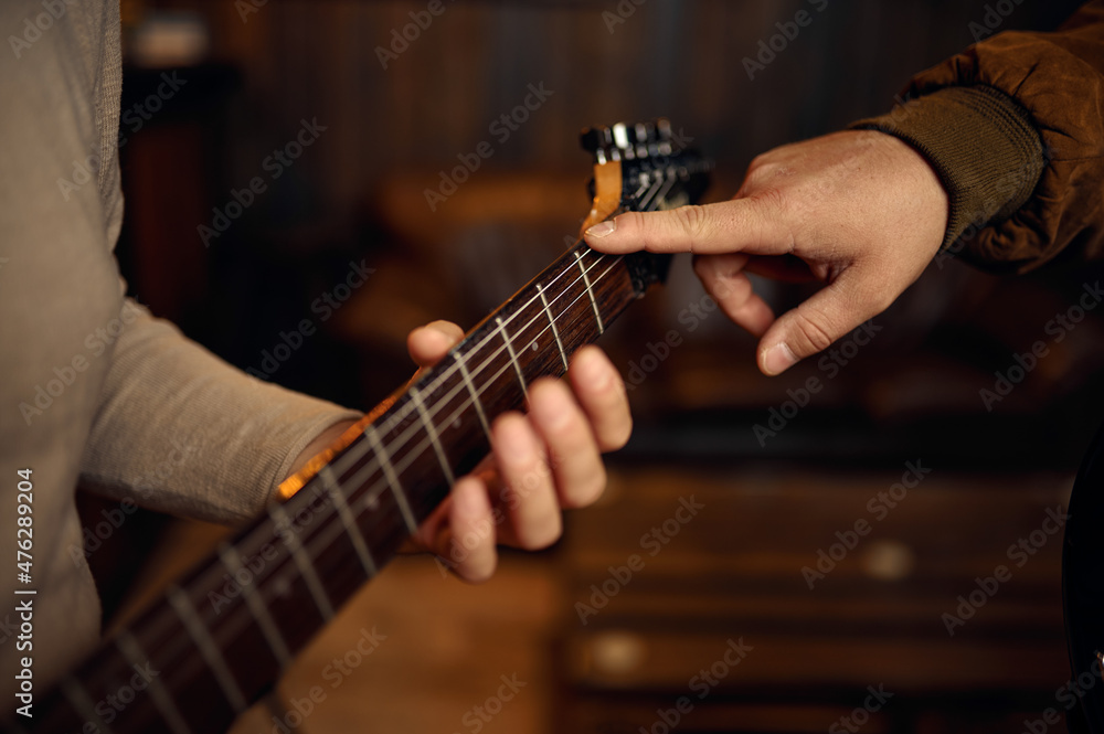 Closeup hand of male musician playing guitar