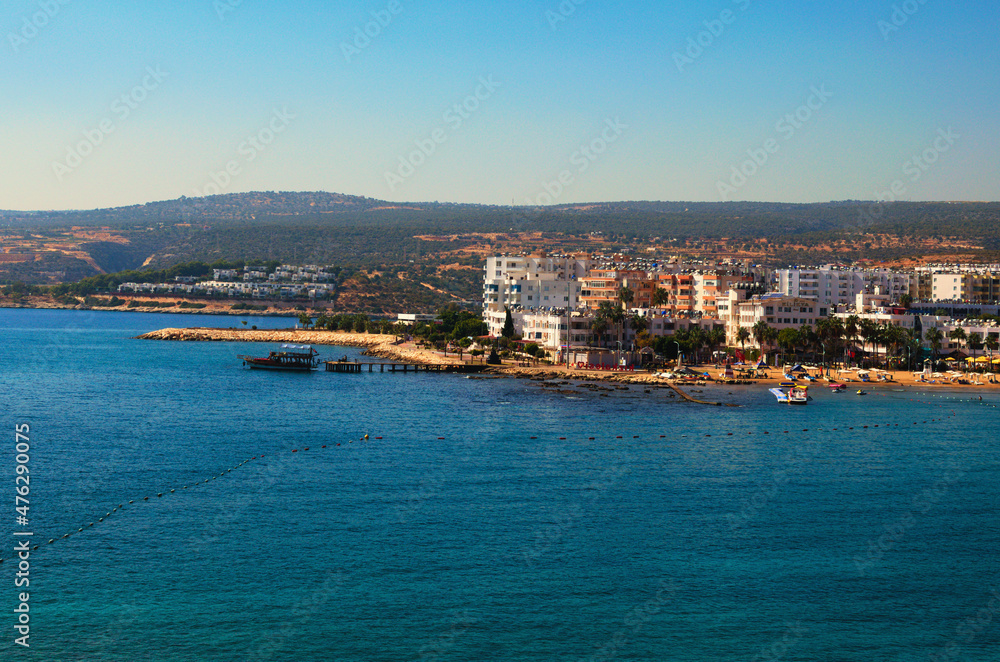 Kizkalesi, Turkey-October 11,2021:Wide angle landscape view of blue water of Mediterranean Sea and city beach, embankment with many hotels in Kizkalesi. Blue sky background. Famous touristic place