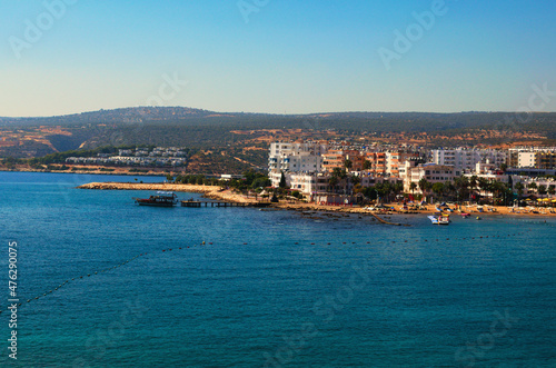 Kizkalesi, Turkey-October 11,2021:Wide angle landscape view of blue water of Mediterranean Sea and city beach, embankment with many hotels in Kizkalesi. Blue sky background. Famous touristic place