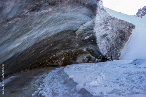 High blue ice wall, ice caves and snow on a sunny day in December. Beautiful scenery in mountains. Bogdanovich glacier, Kazakhstan photo