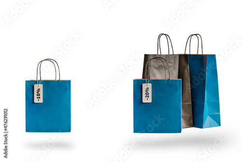 Shopping paper bags of different colors on white isolated background. Discount price tag hanging on sale