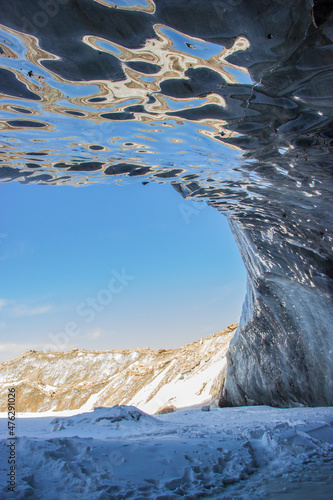 Oktyabrskaya cave of the Bogdanovich glacier in Kazakhstan. View from within and blue cloudy sky.