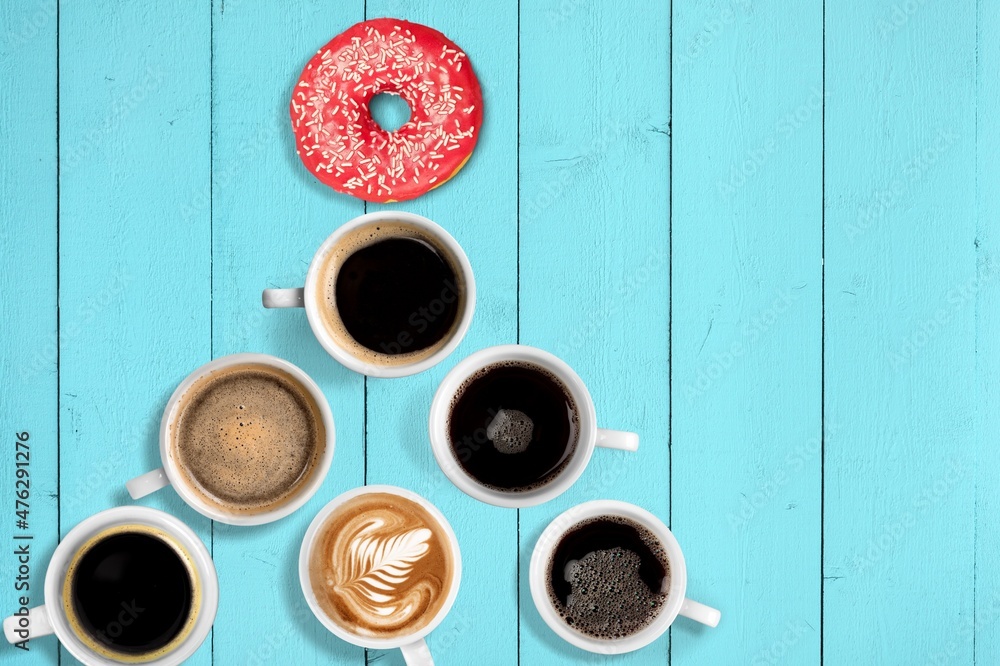Cups with hot drinks, coffee, cappuccino, coffee with milk, Christmas tree shape, blue background. Cups with hot drinks, coffee, cappuccino, coffee with milk, Christmas tree shape, blue background.