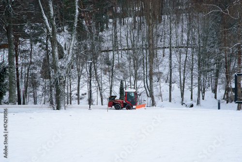 snow removal in the nature park with a tractor in winter