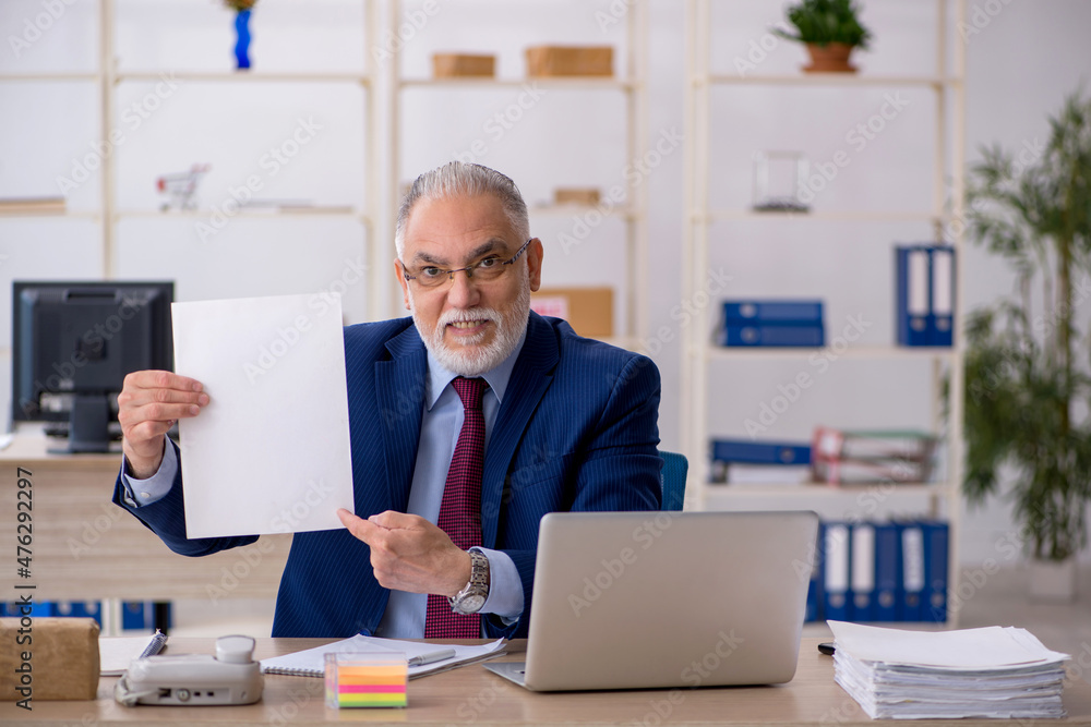 Old male employee working in the office Old male employee working in the office
