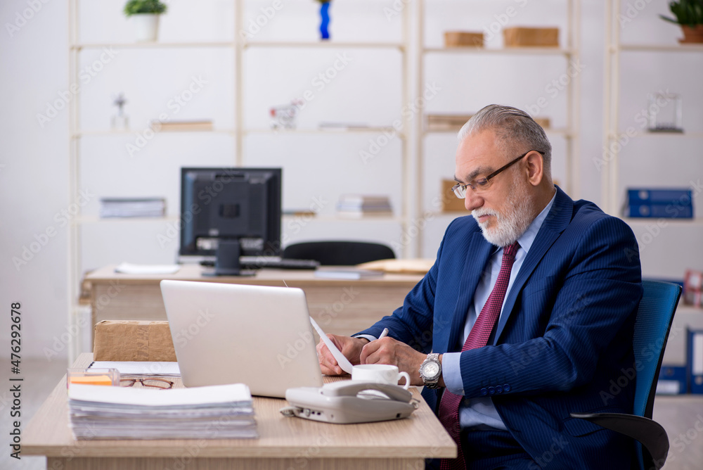 Old male employee working in the office Old male employee working in the office