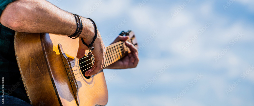 Guitars acoustic. Male musician playing guitar, music instrument. Man's hands playing acoustic guitar, close up. Acoustic guitars playing. Music concept - obrazy, fototapety, plakaty 