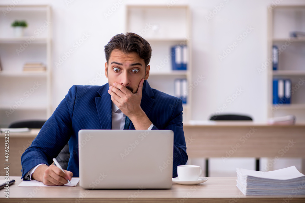 Young male employee working in the office Young male employee working in the office