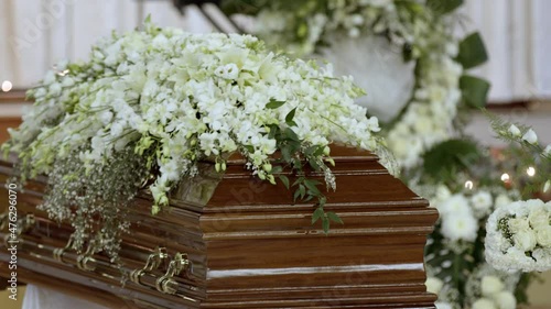 A closeup of a casket with fresh white flowers during the Vietnamese funeral ceremony in 4K