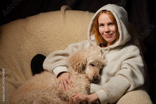 Canvas Print woman lies with a large dog on the couch