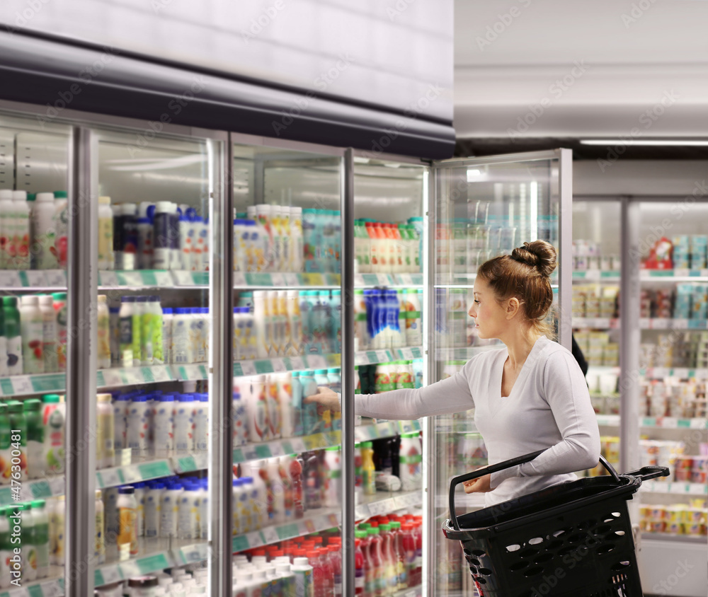 Woman choosing frozen food from a supermarket freezer. Woman choosing frozen food from a supermarket freezer.