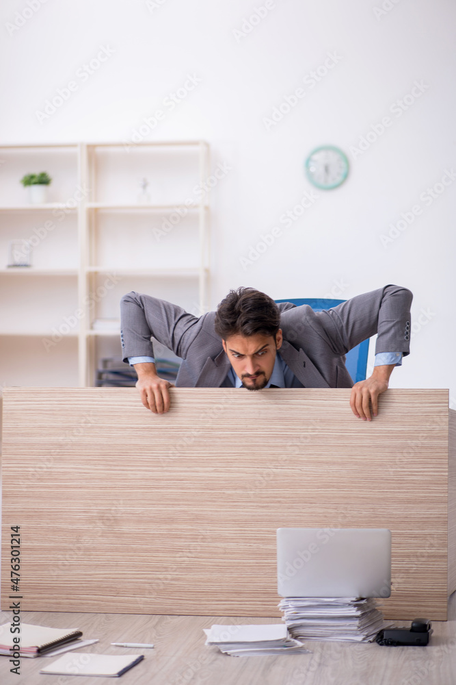 Young male employee working overtime in the office Young male employee working overtime in the office