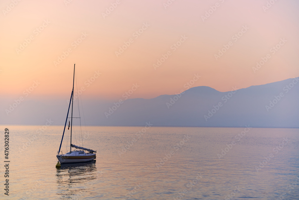 boat moored on a large lake while a beautiful sunset