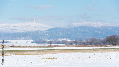 Fototapeta Naklejka Na Ścianę i Meble -  zima pola i góry pokryte śniegiem, na szczycie góry maszt