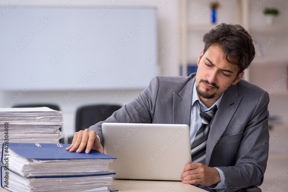 Young businessman employee and too much work in the office Young businessman employee and too much work in the office