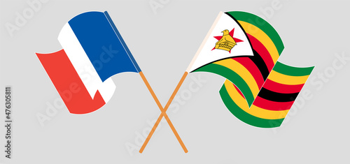 Crossed and waving flags of France and Zimbabwe
