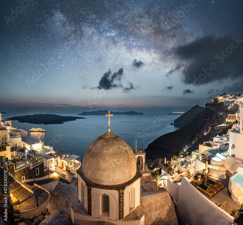 Night image of Fira with old church and buildings on caldera and the milky way in starry night sky