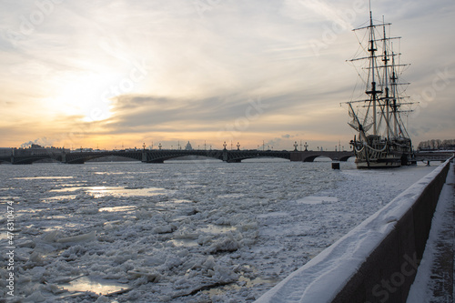 Frozen Neva river with ice, ship, bridge and panorama of St. Petersburg in the background