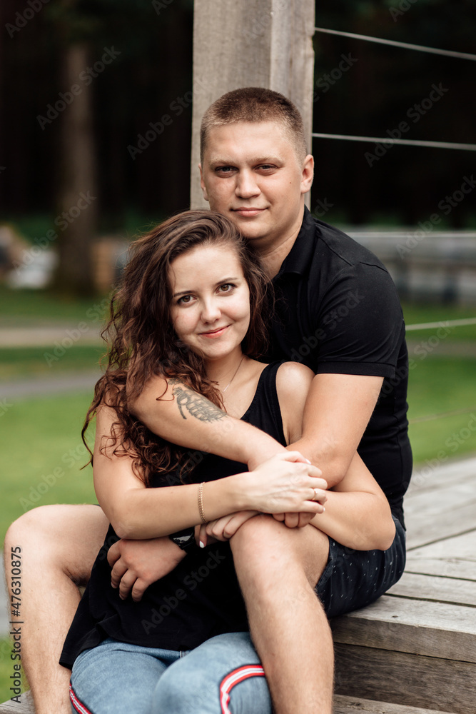 Loving young couple is hugging and kissing on stairs of cafe outdoors on summer day Loving young couple is hugging and kissing on stairs of cafe outdoors on summer day