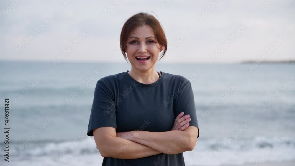 Portrait of smiling middle aged woman looking at camera on beach Portrait of smiling middle aged woman looking at camera on beach