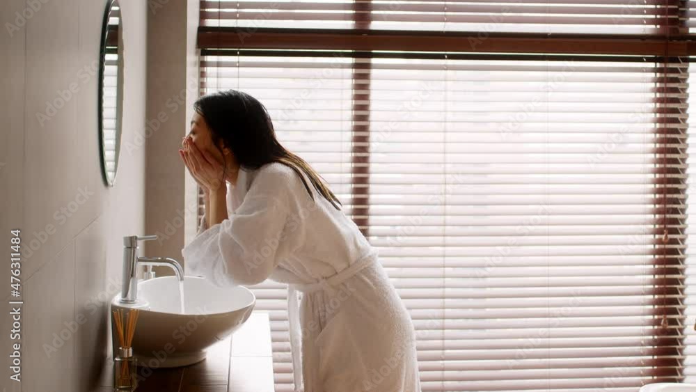 Young Beautiful Asian Lady Wearing Silk Robe Washing Face In Bathroom Young Beautiful Asian Lady Wearing Silk Robe Washing Face In Bathroom