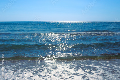 Fototapeta Naklejka Na Ścianę i Meble -  A beautiful blue sea with a wave sparkles in the sun. Natural background of nature, seascape
